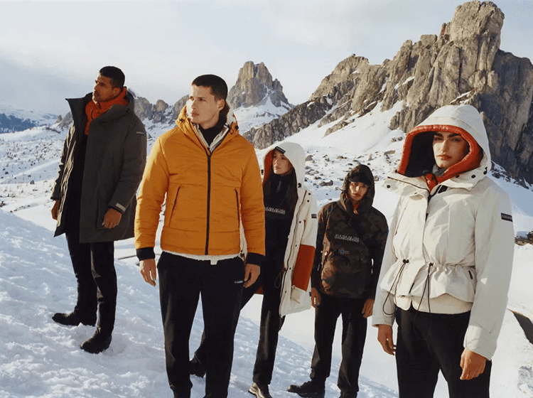 A group of people wearing Napapijri winter outerwear in snow-covered mountain landscape