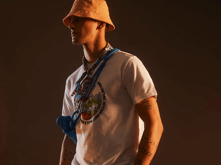 A side profile of a person wearing a bucket hat and layered outfit.