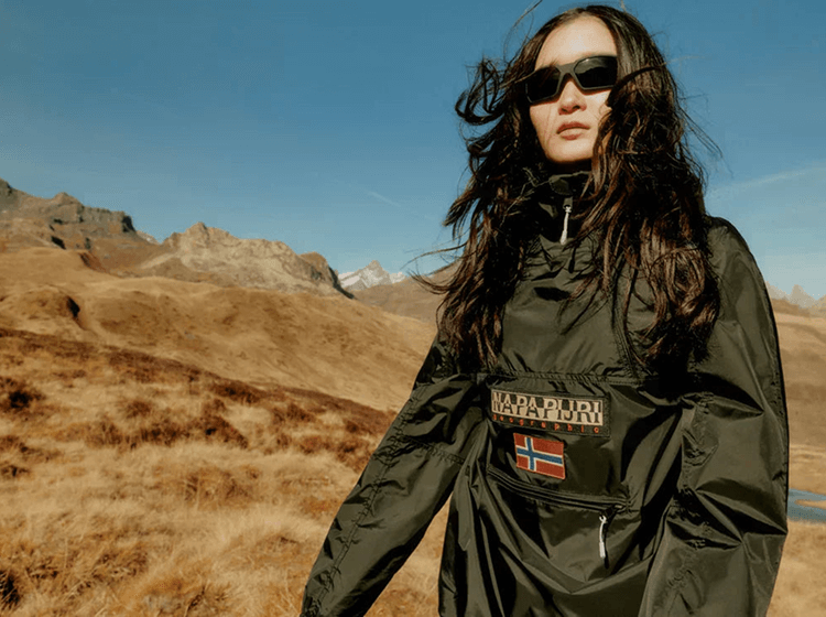 A person wearing Napapijri anorak jacket in black outdoors in a mountain area.