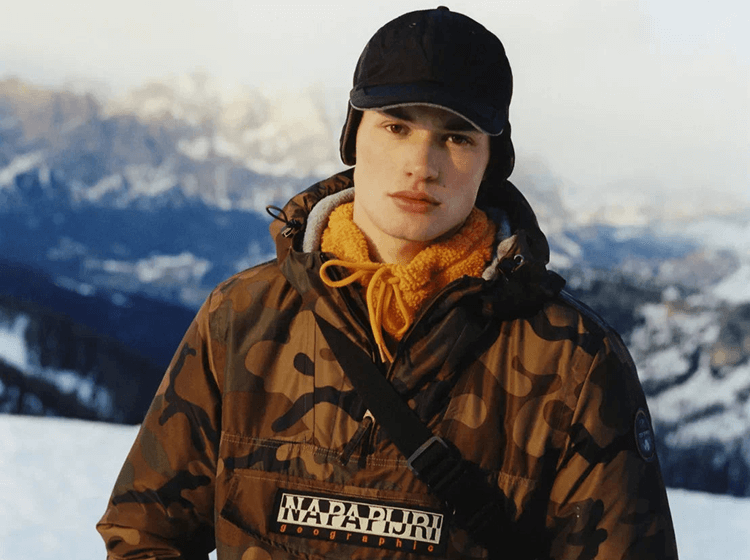 A person wearing Napapijri hat and jacket in cold mountain setting