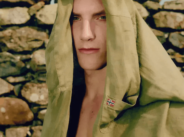 A person wearing Napapijri hooded jacket with fabric texture against stone background