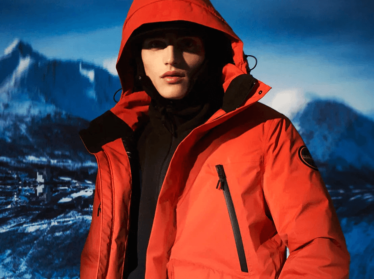 A person wearing Napapijri red hooded jacket close-up in alpine cold-weather setting