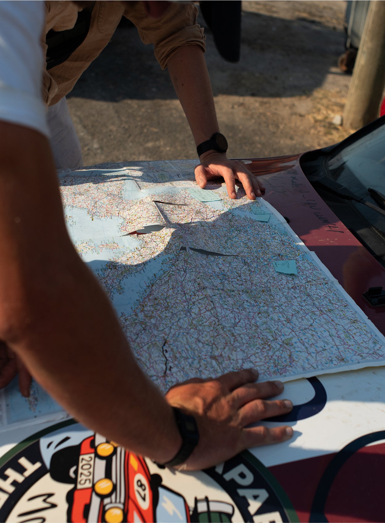 Hands resting on a folded paper map outdoors.