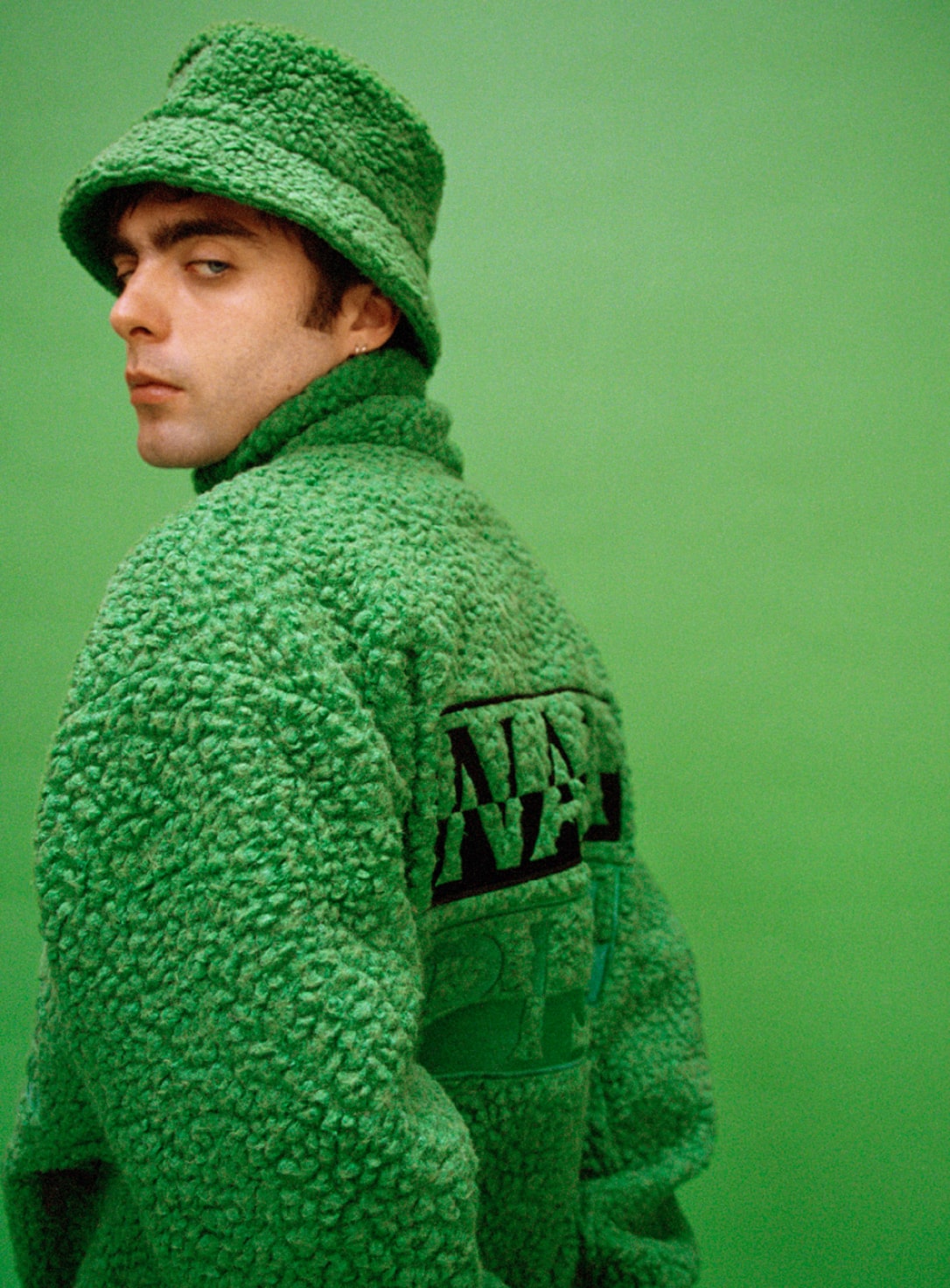 A person wearing green Napapijri fleece jacket with matching bucket hat