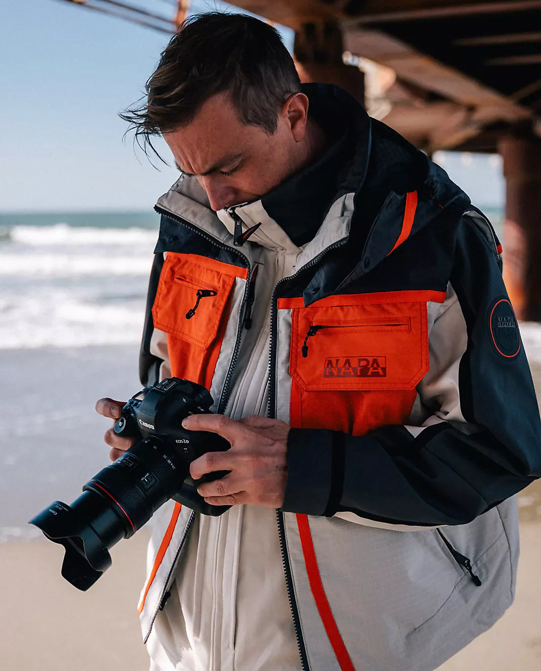 A person wearing Napapijri jacket with chest pockets and logo.